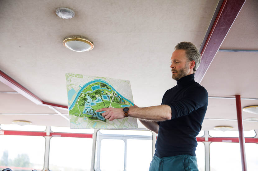 Man houdt een visualisatie vast een wijst er een punt op aan