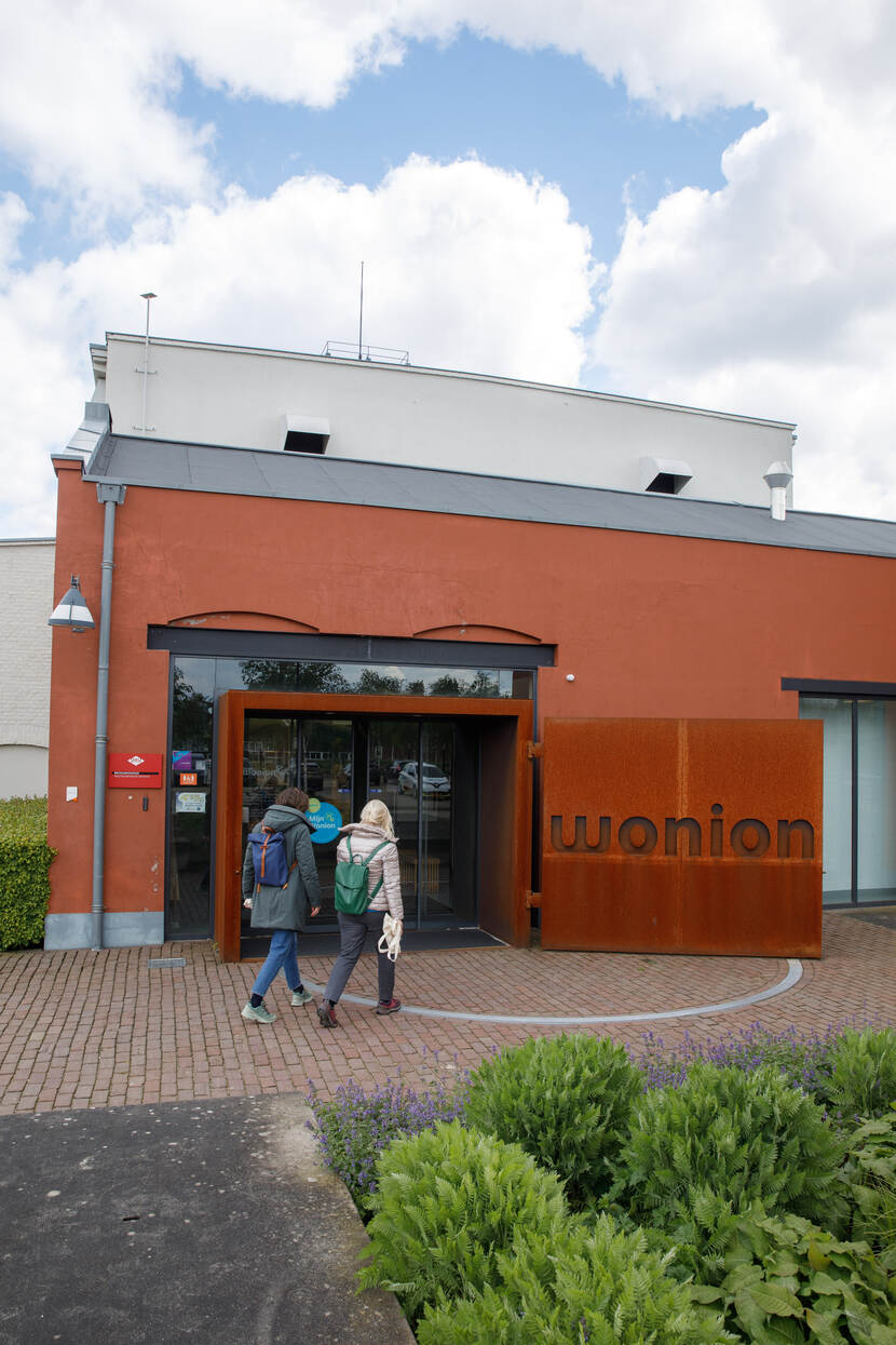 2 mensen lopen richting de ingang van Wonium