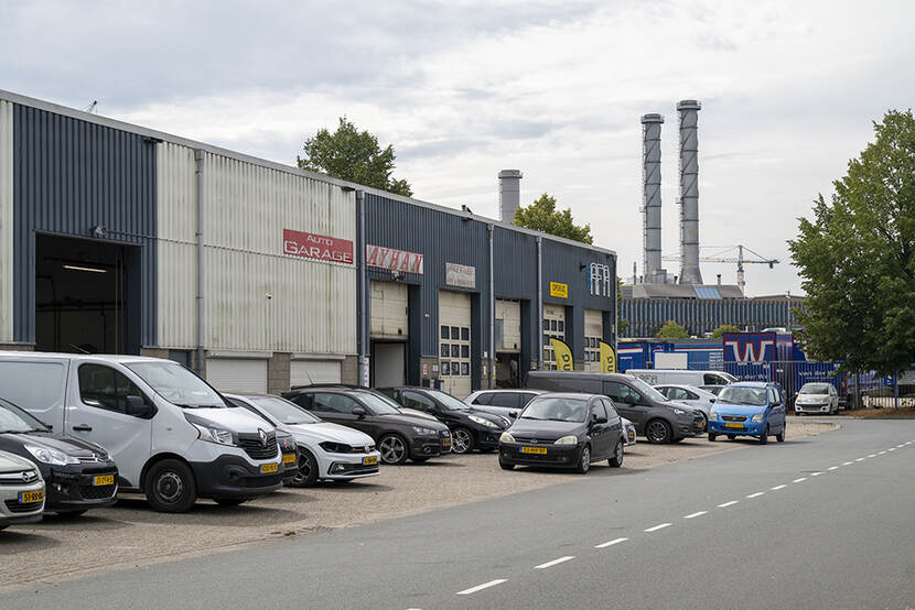 Autogarages met daarvoor auto's geparkeerd.